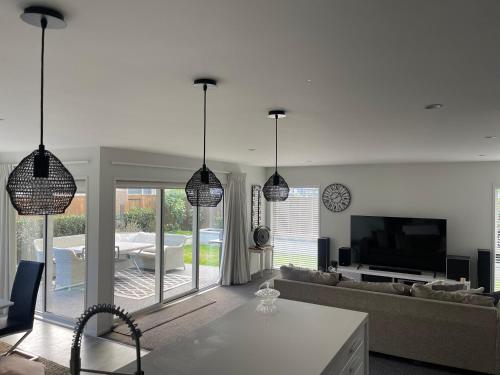 a living room with pendant lights and a couch at Lakes Executive Suites in Tauranga
