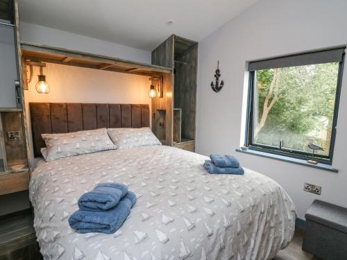 1 dormitorio con 1 cama grande y toallas azules. en Cornerstones Brython en Tenby