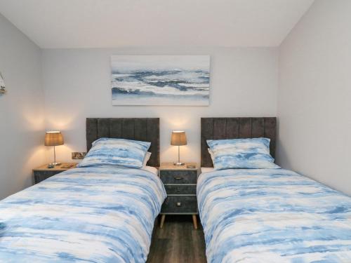 two beds sitting next to each other in a bedroom at Cornerstones Brython in Tenby