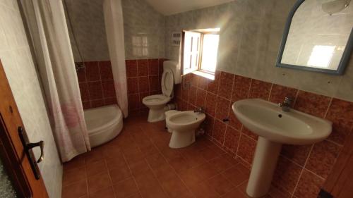 y baño con 2 aseos, lavamanos y bañera. en Vila Mitrojorgji en Shëngjin