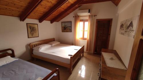 a bedroom with two beds and a window at Vila Mitrojorgji in Shëngjin
