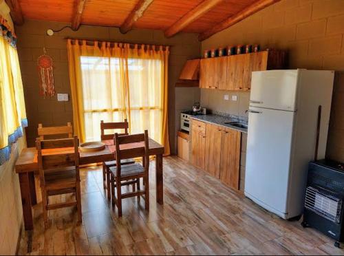 eine Küche mit einem Tisch und einem weißen Kühlschrank in der Unterkunft Tamya-Waira in Charbonier