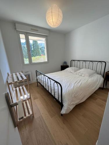 a bedroom with a bed and a wooden floor at Superbe appartement bord de mer in Saint-Mandrier-sur-Mer