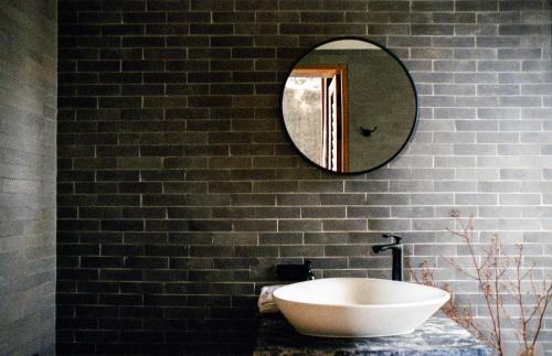 a bathroom with a white sink and a mirror at Na Tanao 1969 in Bangkok