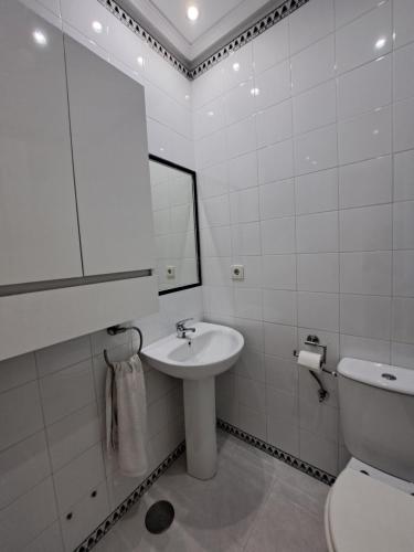 uma casa de banho com um lavatório, um WC e um espelho. em Apartamento Pinares del atlantico em Chiclana de la Frontera