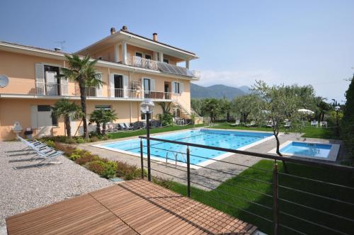 a villa with a swimming pool in front of a house at Hotel Panoramica in Salò