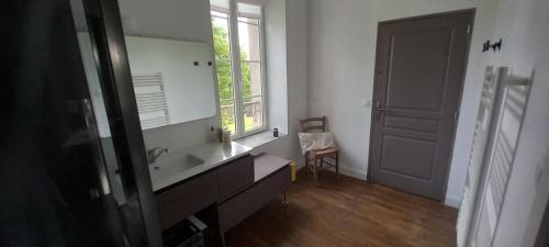 a bathroom with a sink and a large mirror at Chambres d'hôtes La Babinerie in Saint-Léonard-de-Noblat