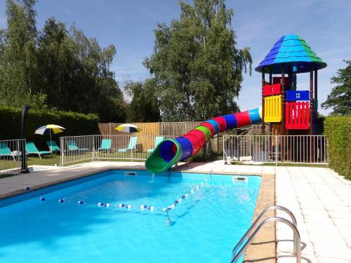 una piccola piscina con scivolo colorato e parco giochi di Camping Smile & Braudieres a Mézières-sous-Lavardin