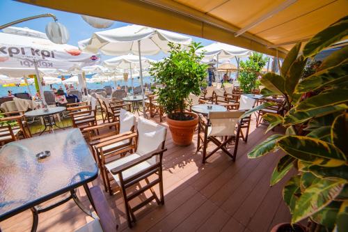 restauracja na świeżym powietrzu ze stołami, krzesłami i parasolami w obiekcie THEMIS BEACH w Paralii Katerinis