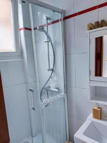 une douche avec une porte vitrée dans une salle de bain dans l'établissement Le Namasté - Petit Déjeuner, Netflix, Jacuzzi, à Rouen