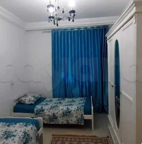 a bedroom with a bed and a blue curtain at App sea view kantaoui in Sousse