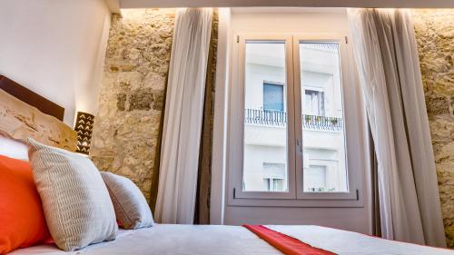 a bedroom with a bed and a window with a balcony at Kalista in Cagliari