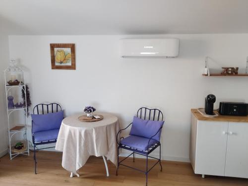 une table avec deux chaises et une table avec des chaises violettes dans l'établissement Le Spa des lavandes panoramique, à Valensole