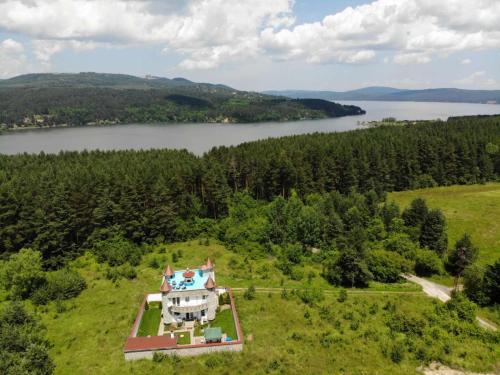 an aerial view of a house in a field with a lake at Къща за гости Замък Никола in Shtarkelovo Gnezdo