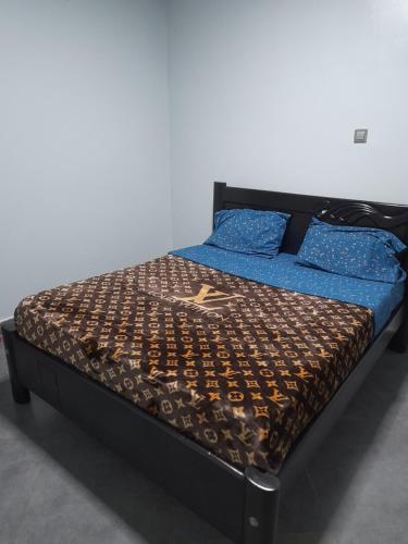 a bed with a black frame and blue sheets at Ella Apartment Namirembe Road in Kampala