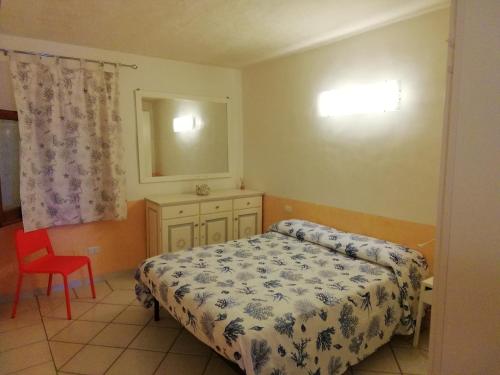 - une chambre avec un lit et une chaise rouge dans l'établissement Casa Giorgia, à Palau