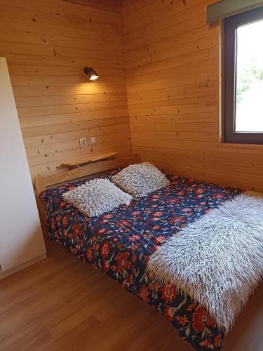 a bedroom with a bed in a wooden room at Domki i apartamenty nad jeziorem solińskim z basenem I widokiem na góry in Wołkowyja