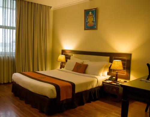 pokój hotelowy z dużym łóżkiem i 2 lampami w obiekcie Vannasut Hotel and Spa w Katmandu
