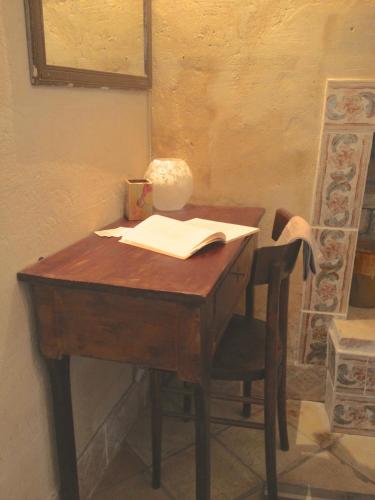 a desk with a lamp and an open book on it at Casa Contini in Matera