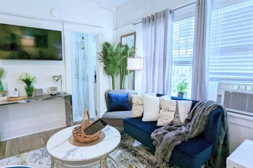a living room with a blue couch and a table at Metro Paris - 3 Day Minimum - Secluded Studio near the Long Beach Harbor in Long Beach