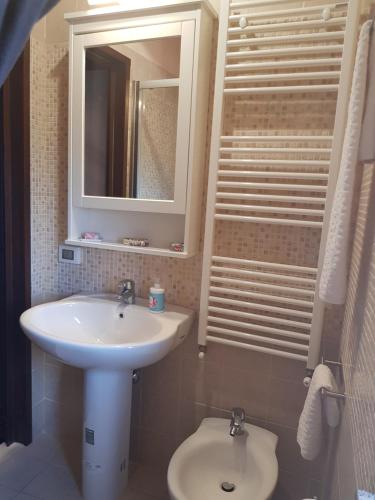 een badkamer met een wastafel, een spiegel en een toilet bij Quiete del Sirino in Moliterno