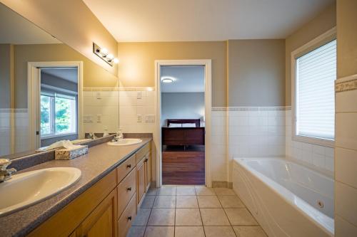 baño con 2 lavabos, bañera y tubermott en First Estate Winery, en Peachland