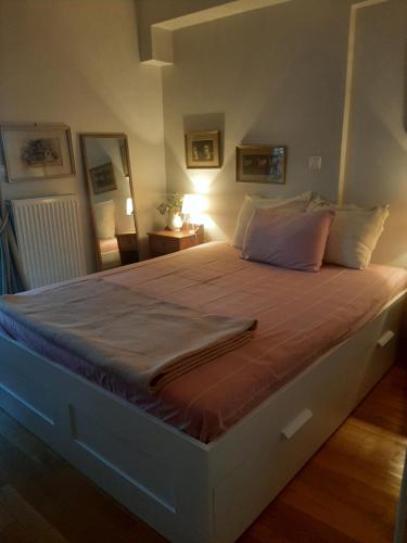 ein großes Bett in einem Schlafzimmer mit einer Lampe in der Unterkunft Modern Apartment near Airport in Athen