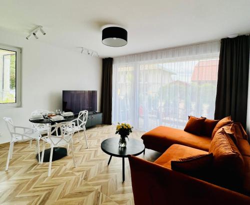 a living room with a couch and a table at SunBaltic Premium Ustka, Przy Lesie, Dwa Tarasy, Klimatyzacja, Parking in Ustka