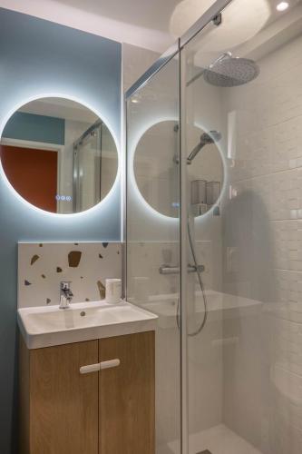 a bathroom with a sink and a shower with a mirror at Bel appartement idéalement situé in Orléans