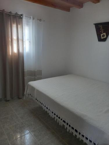 ein Schlafzimmer mit einem weißen Bett in einem Zimmer in der Unterkunft Νύμφη in Kimolos