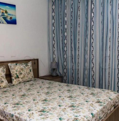a bedroom with a bed with a blue curtain at Front of sea with pool appartement in Sousse