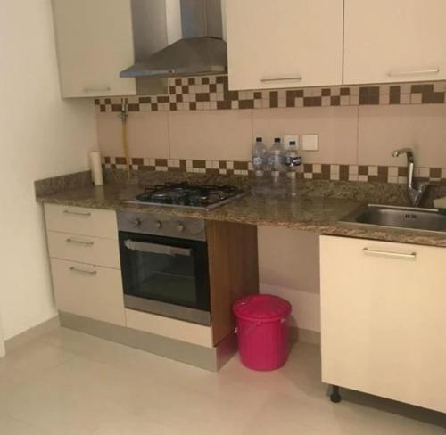 a kitchen with a sink and a stove top oven at Front of sea with pool appartement in Sousse