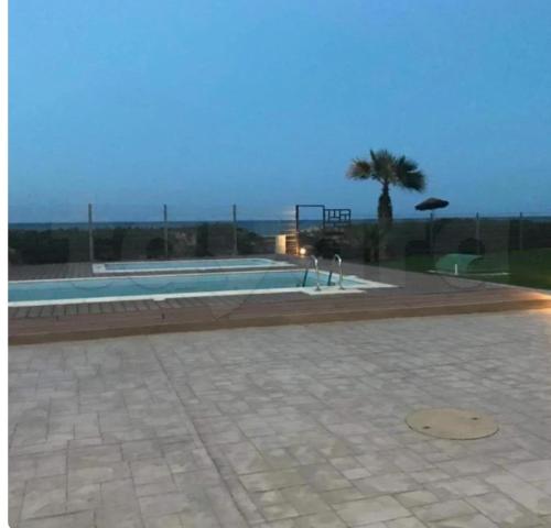a swimming pool with a view of the ocean at Front of sea with pool appartement in Sousse