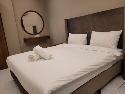 um quarto com uma grande cama branca e um espelho em Salalah Beach Villas em Salalah