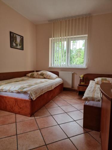 a bedroom with two beds and a window at Zacisze Konopnickiej in Pobierowo