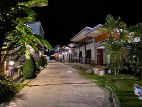 an empty street at night with houses and trees at พูลสวัสดิ์ รีสอร์ท อ่าวมะนาว in Changwat Prachuap Khiri Khan