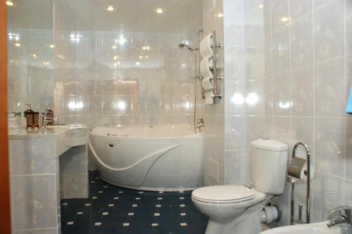 a bathroom with a tub and a toilet and a sink at Hotel Aristokrat Kostroma in Kostroma