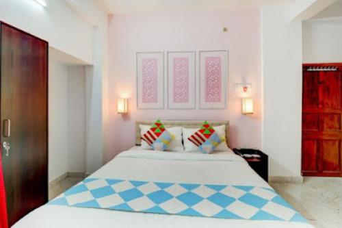 - une chambre avec un grand lit blanc et des oreillers dans l'établissement GRG priyanshu Guest House Ruby Kolkata, à Jādabpur