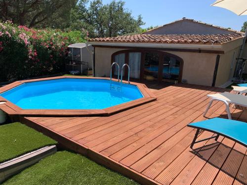 une terrasse en bois avec une piscine à l'arrière-cour dans l'établissement Prox Saint-Tropez - Maison 3 Chambres- 3 km Mer, à Grimaud