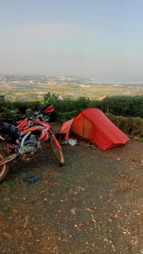 a red tent and a motorcycle parked next to it at Lago Resort - Best Views in Kisumu in Kisumu