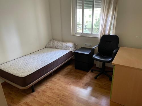 1 dormitorio con cama, escritorio y silla en XRYHOMES I Residencial en Jerez 4 hab, 2 baños, 7pax, 10 min del centro, en Jerez de la Frontera