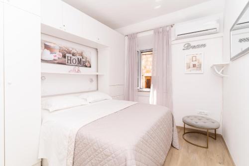 ein weißes Schlafzimmer mit einem Bett und einem Fenster in der Unterkunft Apartment Cameleon in Dubrovnik