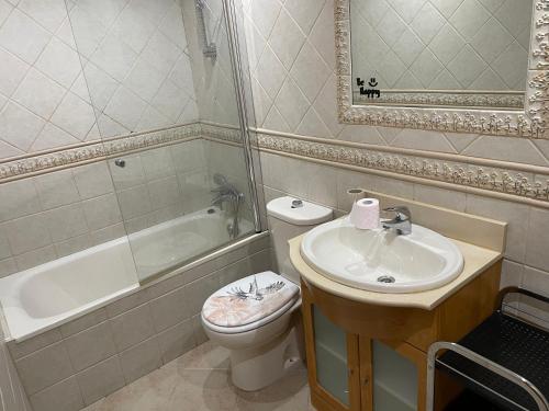 y baño con lavabo, aseo y bañera. en XRYHOMES I Residencial en Jerez 4 hab, 2 baños, 7pax, 10 min del centro, en Jerez de la Frontera