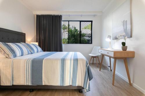 a bedroom with a bed and a desk and a window at Resort Living, Luxury Getaway, Close 2 Noosa River in Noosaville