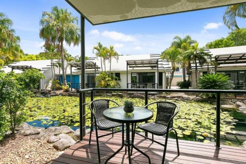 a patio with two chairs and a table on a balcony at Resort Living, Luxury Getaway, Close 2 Noosa River in Noosaville