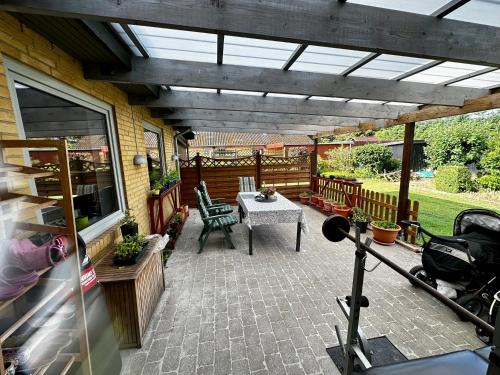 een patio met een tafel en stoelen op een huis bij OJ Home in Vojens