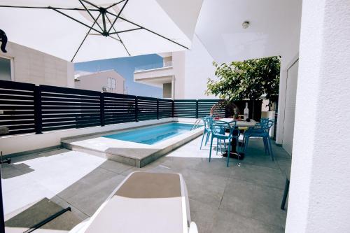 a patio with a table and a swimming pool at Villa TINA in Novalja