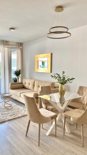 uma sala de estar com um sofá, uma mesa e cadeiras em Eastlake Apartman em Alsóörs