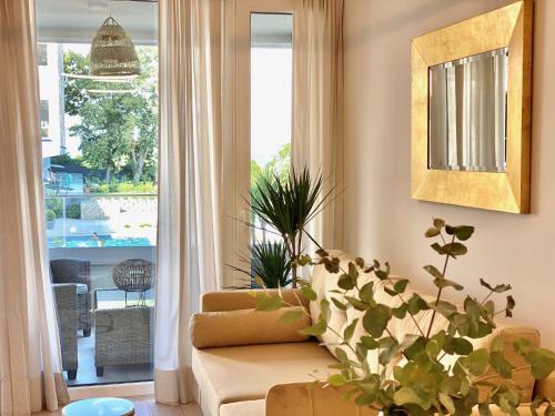 a living room with a couch and a large window at Eastlake Apartman in Alsóörs