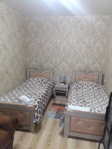 two twin beds in a room with a wall at Art-Rabath in Akhaltsikhe